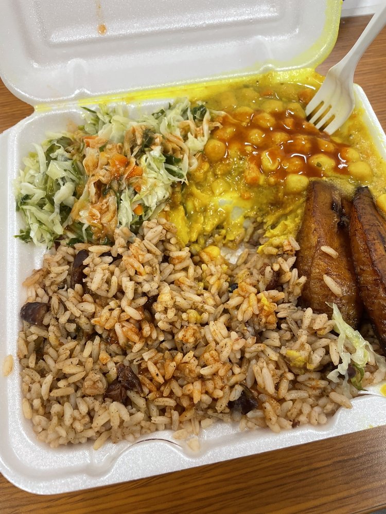 Curry plate with rice and peas, plantains, and cabbage